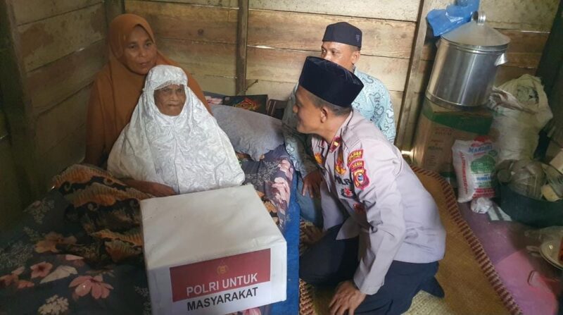 Foto: Kapolsek Tanah Luas, Ipda Marzuki Saat Menyerahkan Bingkisan Kepada Warga Miskin